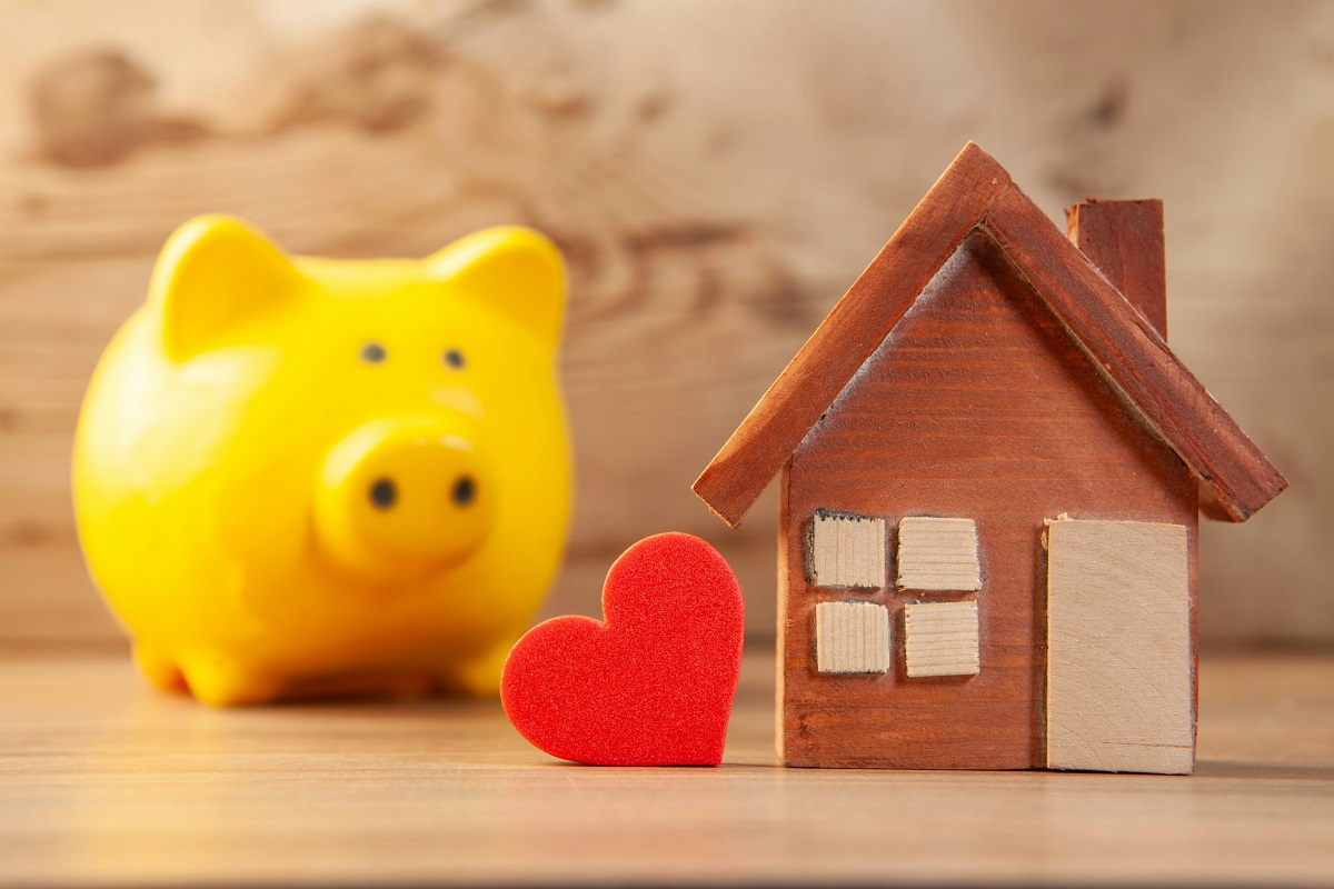 yellow piggy bank and miniature house